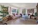 Bright living room featuring a neutral sofa, tile floors, and large bay windows offering natural light at 1040 E Clinton St, Phoenix, AZ 85020