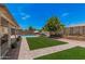 Lush backyard featuring a pool, green lawn, and paved area, perfect for outdoor relaxation at 10852 E Contessa St, Mesa, AZ 85207