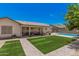Beautiful backyard with lush green lawn, covered patio, and refreshing swimming pool, perfect for outdoor enjoyment at 10852 E Contessa St, Mesa, AZ 85207
