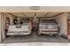 View of a two-car garage holding two vehicles, shelving, and additional storage space at 10852 E Contessa St, Mesa, AZ 85207