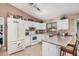 Bright kitchen features white appliances and breakfast bar with stool seating, ideal for casual dining at 10852 E Contessa St, Mesa, AZ 85207