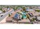 Aerial view of a home with solar panels, and a pool with rock waterfall features in a desert community at 10943 W Alice Ave, Peoria, AZ 85345