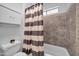 Bathroom featuring a shower with neutral tile and tub and toilet with white cabinets at 10943 W Alice Ave, Peoria, AZ 85345