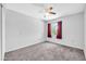 Neutral bedroom with carpet flooring, ceiling fan, and a large window at 10943 W Alice Ave, Peoria, AZ 85345