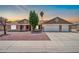 Charming single-story home with a three car garage and well-kept yard at sunset at 10943 W Alice Ave, Peoria, AZ 85345
