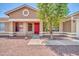Charming single-story home featuring a red door, desert landscaping, and inviting curb appeal at 10943 W Alice Ave, Peoria, AZ 85345
