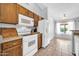 Cozy kitchen includes wood cabinets, white appliances, and breakfast nook with natural light at 10943 W Alice Ave, Peoria, AZ 85345