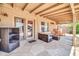 Comfortable covered patio space with stylish outdoor furniture and stone flooring at 10943 W Alice Ave, Peoria, AZ 85345