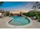 Lush backyard pool with a rock waterfall feature, seating, and relaxing ambiance at 10943 W Alice Ave, Peoria, AZ 85345