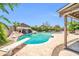 Beautiful backyard with a large pool, rock waterfall, diving board and lush greenery at 10943 W Alice Ave, Peoria, AZ 85345