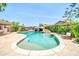 Backyard pool with a rock waterfall feature and lush landscaping, perfect for outdoor relaxation at 10943 W Alice Ave, Peoria, AZ 85345