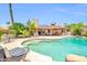 Beautiful pool area with lounging furniture, lush greenery, and clear blue water at 10943 W Alice Ave, Peoria, AZ 85345
