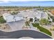 Aerial view of a modern home with desert landscaping, a circular driveway, a three-car garage, and a guest house at 11250 W Prospector Dr, Queen Creek, AZ 85144