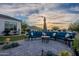 Inviting back patio featuring blue outdoor seating, patio umbrella, mountain views, and lush desert landscaping at 11250 W Prospector Dr, Queen Creek, AZ 85144