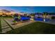Beautiful backyard with an inviting pool, a cozy fire pit area, and well-manicured green space for relaxing at 11250 W Prospector Dr, Queen Creek, AZ 85144