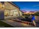 Luxurious backyard featuring a covered patio, fire pit, pool with water features, and colorful landscaping at 11250 W Prospector Dr, Queen Creek, AZ 85144
