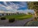 Expansive backyard featuring a large green lawn, manicured landscaping, and a brick pathway at 11250 W Prospector Dr, Queen Creek, AZ 85144