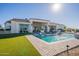 An eye-catching home exterior features a modern pool, manicured landscaping, and attached outdoor kitchen at 11250 W Prospector Dr, Queen Creek, AZ 85144