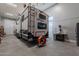 Spacious garage featuring an 'Imagine' camper with overhead hoist and storage, drill press, and a convenient fan at 11250 W Prospector Dr, Queen Creek, AZ 85144
