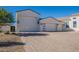 Spacious three-car garage with modern doors and stylish exterior lighting, complementing the home's architecture at 11250 W Prospector Dr, Queen Creek, AZ 85144