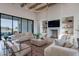 A bright modern living room with hardwood floors, oversized windows, and a stacked stone fireplace at 11250 W Prospector Dr, Queen Creek, AZ 85144