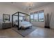 Serene main bedroom featuring a four-poster bed, neutral color palette, and large windows at 11250 W Prospector Dr, Queen Creek, AZ 85144