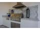 Outdoor kitchen features stainless steel grill and hood, marble countertops, lighting, and stylish decor at 11250 W Prospector Dr, Queen Creek, AZ 85144