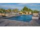 Beautiful backyard pool with water features, palm trees, and a well-manicured landscape for ultimate relaxation at 11250 W Prospector Dr, Queen Creek, AZ 85144