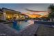 Stunning backyard pool at sunset with water features and covered patio at 11250 W Prospector Dr, Queen Creek, AZ 85144