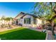 Backyard featuring artificial grass, brick pavers, play equipment, and mature landscaping at 12062 W Duane Ln, Peoria, AZ 85383