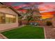 Green backyard features a grassy area, string lights, and seating to relax at 12062 W Duane Ln, Peoria, AZ 85383