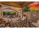 Relaxing covered patio with comfortable seating and desert landscaping at sunset at 12062 W Duane Ln, Peoria, AZ 85383