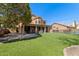 Spacious backyard with artificial grass, covered patio, barbecue, and wrought iron fence at 1211 E Desert Flower Ln, Phoenix, AZ 85048
