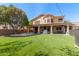Beautiful backyard with green lawn, covered patio, desert landscaping, and string lights at 1211 E Desert Flower Ln, Phoenix, AZ 85048