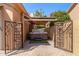 Enclosed backyard features a hot tub, privacy wall, brick pavers, and wrought iron gate at 1211 E Desert Flower Ln, Phoenix, AZ 85048