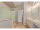 Bathroom featuring a glass shower, neutral vanity with dual sinks, large mirror, and travertine tile floor at 1211 E Desert Flower Ln, Phoenix, AZ 85048