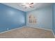 Bedroom with tan carpet, light blue walls, and a large arched window at 1211 E Desert Flower Ln, Phoenix, AZ 85048