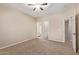 Spacious bedroom with neutral carpet, ensuite access, and bright ceiling fan at 1211 E Desert Flower Ln, Phoenix, AZ 85048