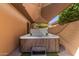 Outdoor covered hot tub on a brick patio, features privacy wall and landscaping at 1211 E Desert Flower Ln, Phoenix, AZ 85048