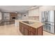 Spacious kitchen featuring granite countertops, cooktop island, stainless steel refrigerator, and adjacent fireplace at 1211 E Desert Flower Ln, Phoenix, AZ 85048