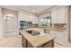 Beautiful kitchen featuring an island with cooktop, granite counters, stainless appliances, and ample storage at 1211 E Desert Flower Ln, Phoenix, AZ 85048