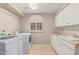 Bright laundry room with white cabinets, sink, and modern washer and dryer at 1211 E Desert Flower Ln, Phoenix, AZ 85048