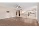 Open-concept living room with wood floors, kitchen, and dining area at 1211 E Desert Flower Ln, Phoenix, AZ 85048