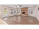 Living room with hardwood floors, stacked stone fireplace, and lots of natural light at 1211 E Desert Flower Ln, Phoenix, AZ 85048