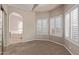 Bright main bedroom boasts neutral palette, carpet, shutters, and access to ensuite bathroom with a soaking tub at 1211 E Desert Flower Ln, Phoenix, AZ 85048