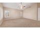 Spacious main bedroom with neutral color palette, carpeted floor, ceiling fan, and windows with plantation shutters at 1211 E Desert Flower Ln, Phoenix, AZ 85048