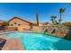 Backyard pool with baja step, rock waterfall feature, desert landscaping, and mature trees at 1211 E Desert Flower Ln, Phoenix, AZ 85048