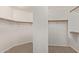 Spacious walk-in closet with carpet, wood rods, shelving, and ample storage at 1211 E Desert Flower Ln, Phoenix, AZ 85048