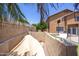 View of backyard with tan stucco wall surrounding, offering privacy and shade from mature trees at 12933 W Monterey Way, Avondale, AZ 85392