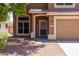 Inviting home exterior featuring a secure screen door, desert landscaping, and a warm, neutral color palette at 12933 W Monterey Way, Avondale, AZ 85392
